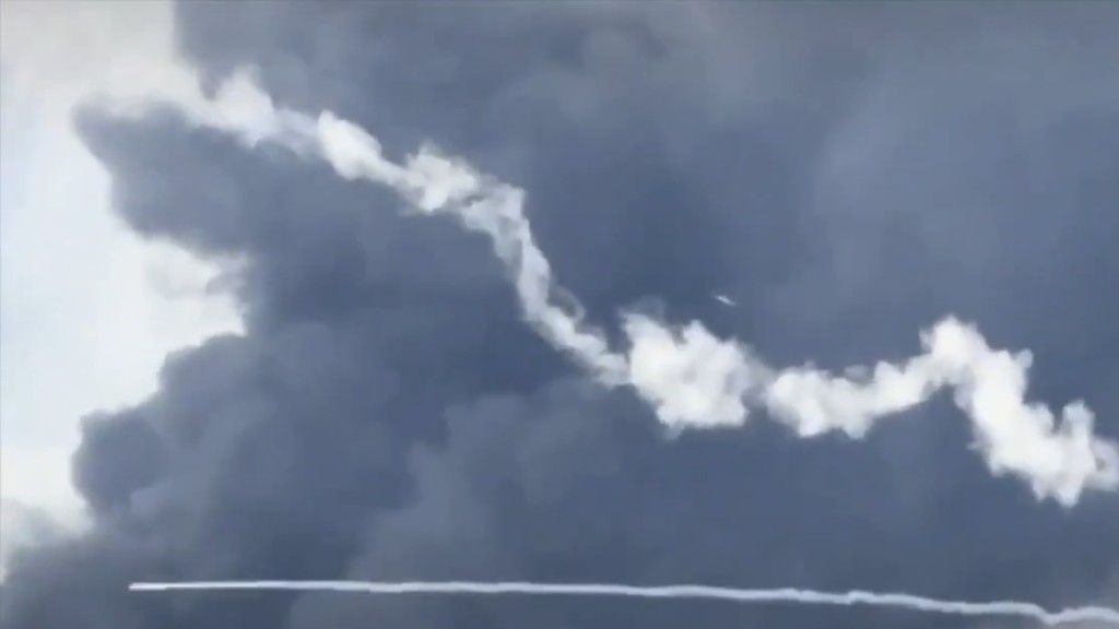 画面显示一枚防空导弹往上飞没击中无人机，另一枚防空导弹朝着储油槽低空横飞。 抖音@李子阳
