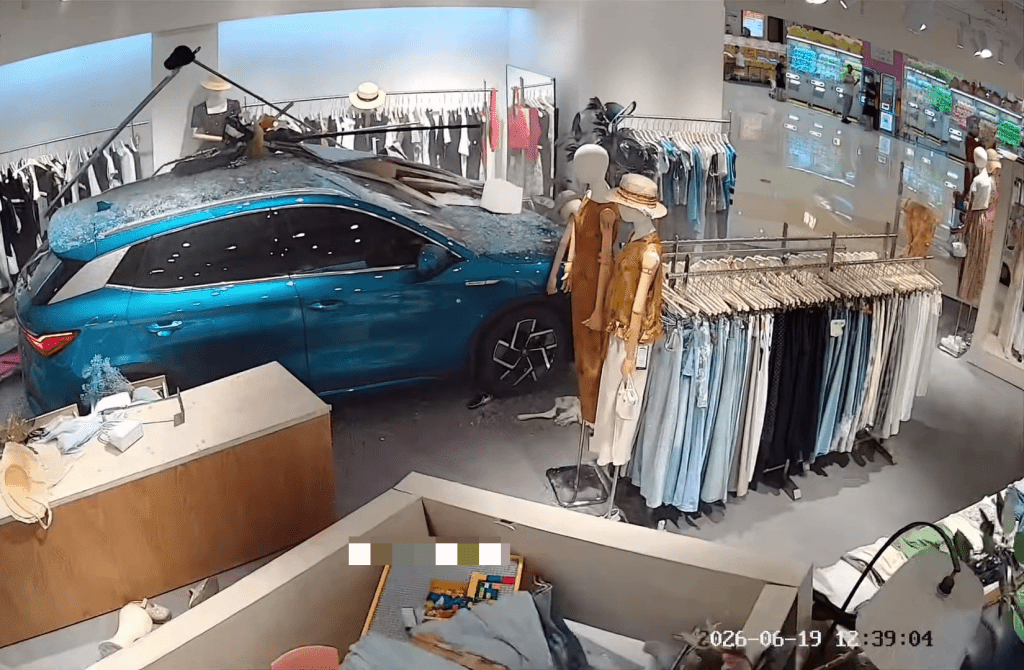 蓝色SUV失控直冲入服装店后终于停了下来。 蓝色SUV失控直冲入服装店后终于停了下来。