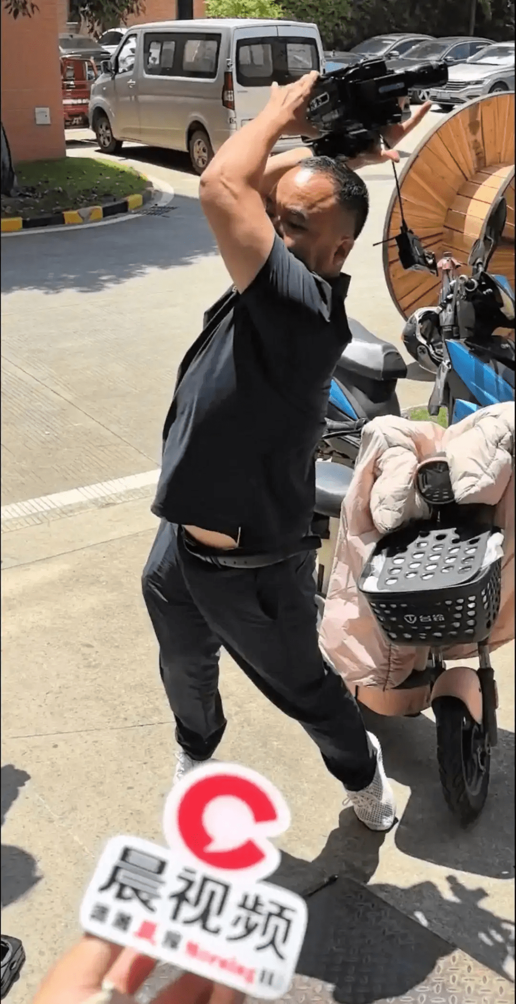 公司负责人摔毁记者拍摄设备。 公司负责人摔毁记者拍摄设备。