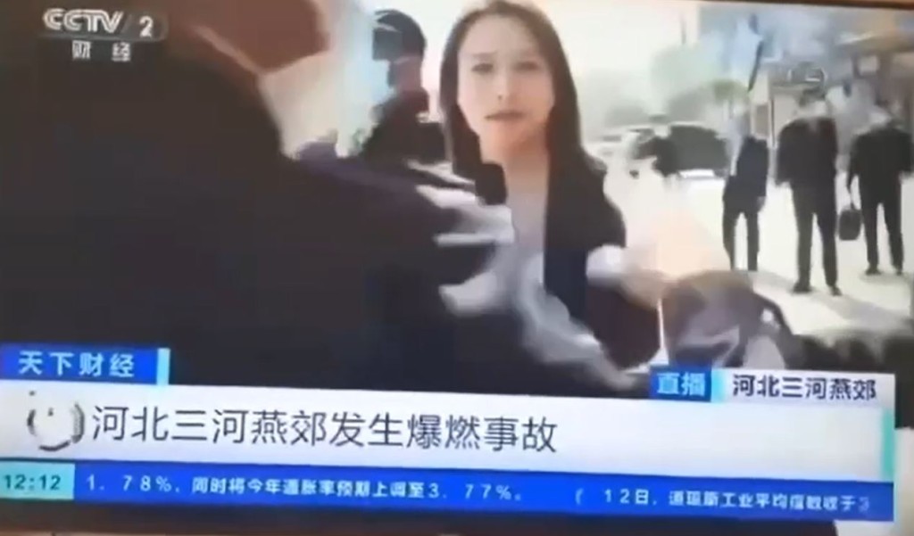 有制服人员故意阻挡镜头。(央视截图)