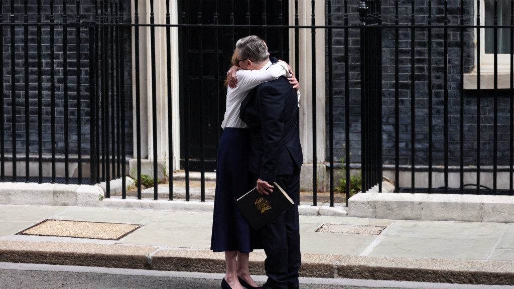 英国首相施纪贤宣布辞职,妻子拥抱给予支持。 路透社 英国首相施纪贤宣布辞职,妻子拥抱给予支持。 路透社