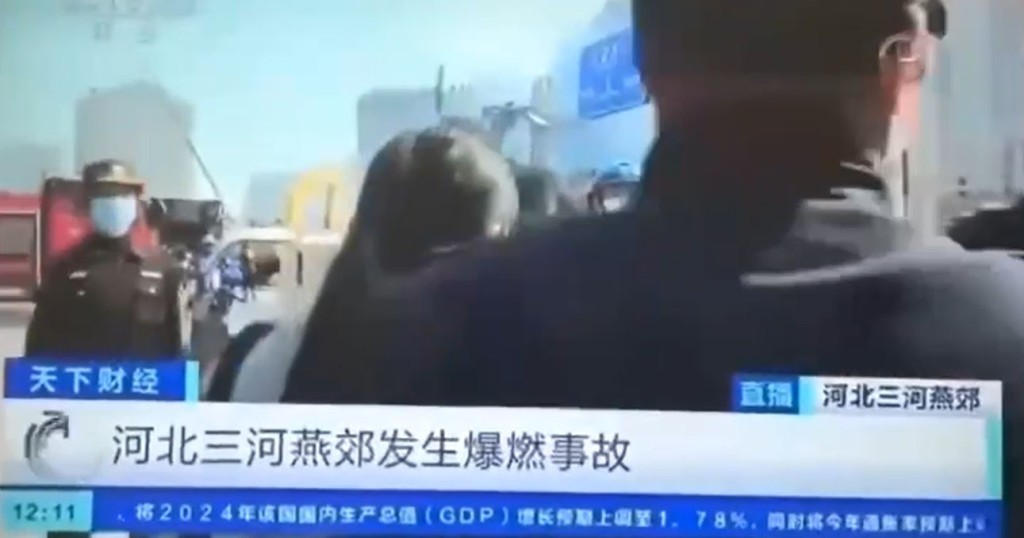 有制服人员故意阻挡镜头。(央视截图)