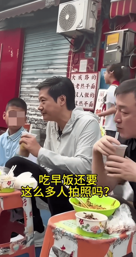 雷军武汉街头吃早餐,正与身边的小男孩聊天时,身后路过一名小女孩。 雷军武汉街头吃早餐,正与身边的小男孩聊天时,身后路过一名小女孩。