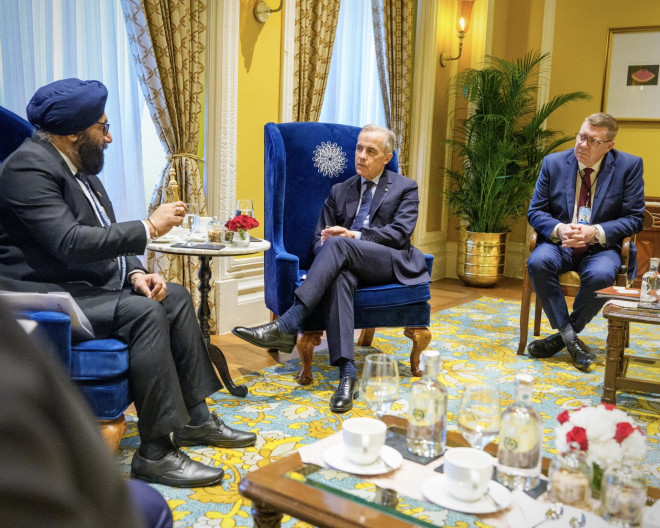 Photo of Prime Minister Carney and Premier Moe meeting business leaders in Mumbai, India.