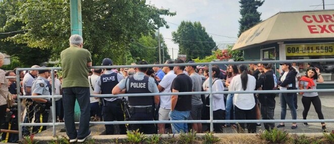 警方在 2026 年 8 月 16 日监控北温 Apadana 兑换行外,数十名顾客要求知道资金去向。